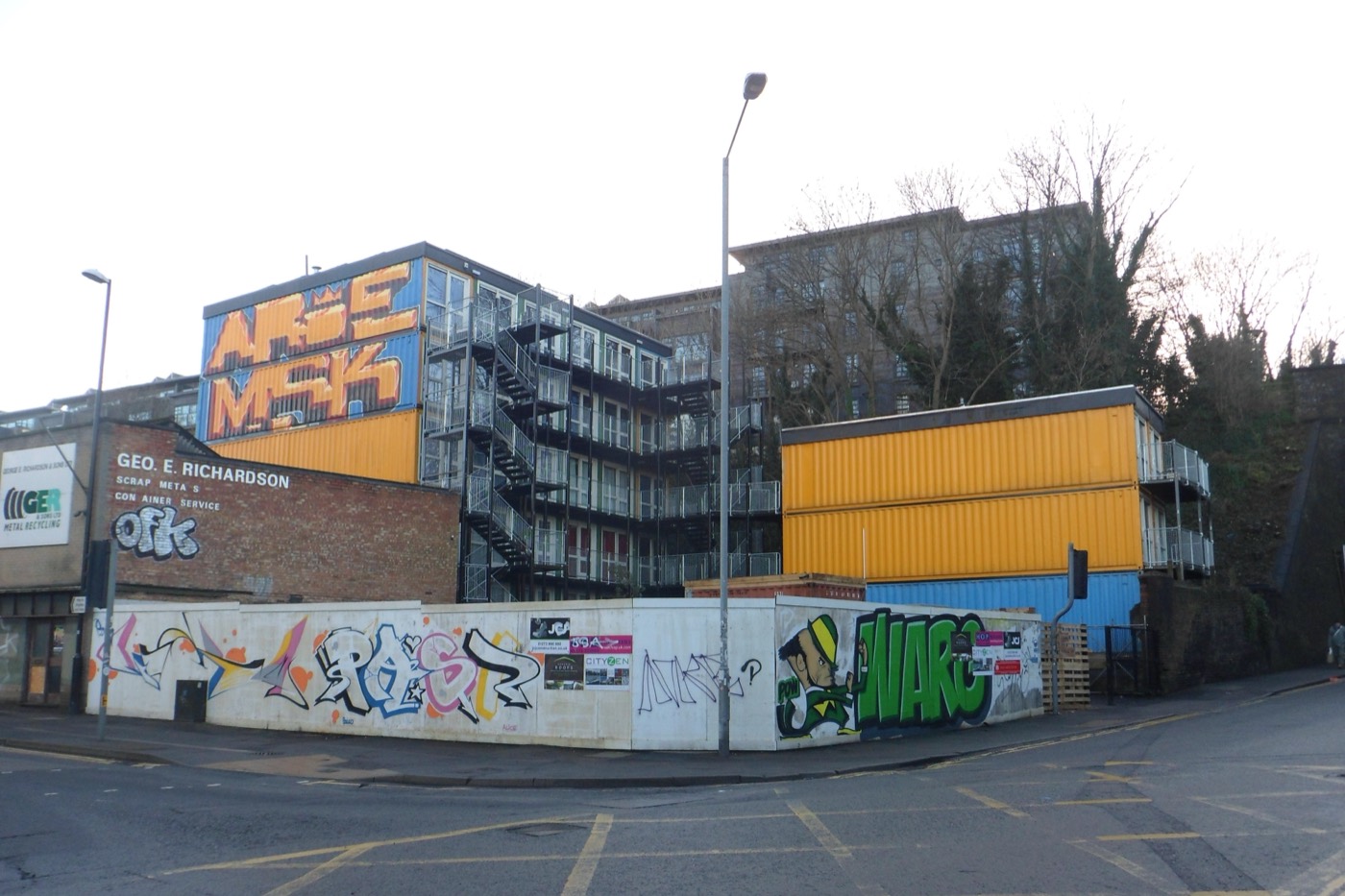A five-storey stack of shipping containers converted into flats, with external steel stairs and walkways, in Brighton in 2013