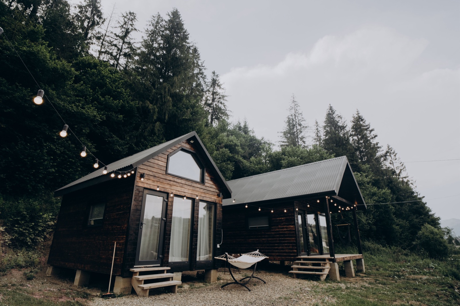A small wooden tiny house cabin in a forest clearing