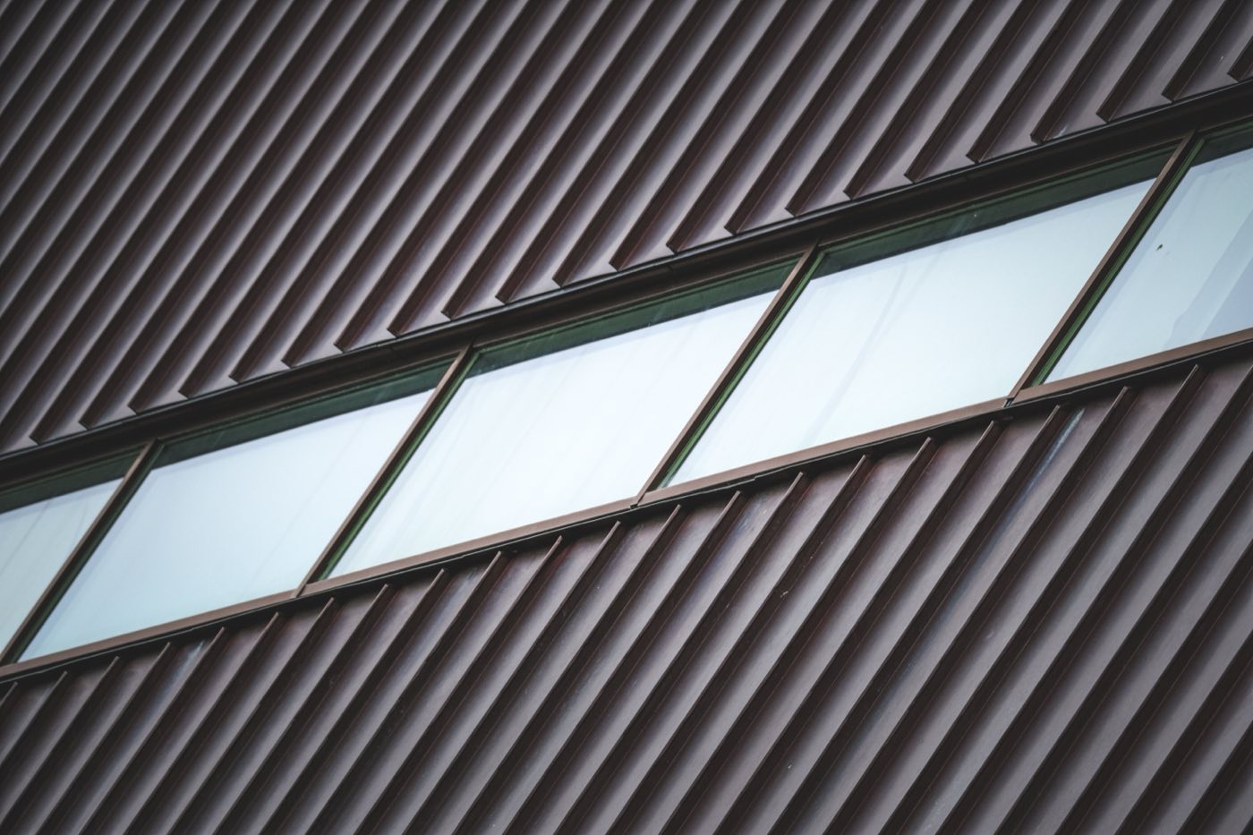 Close view of a standing seam metal roof showing raised interlocking seams running down the slope