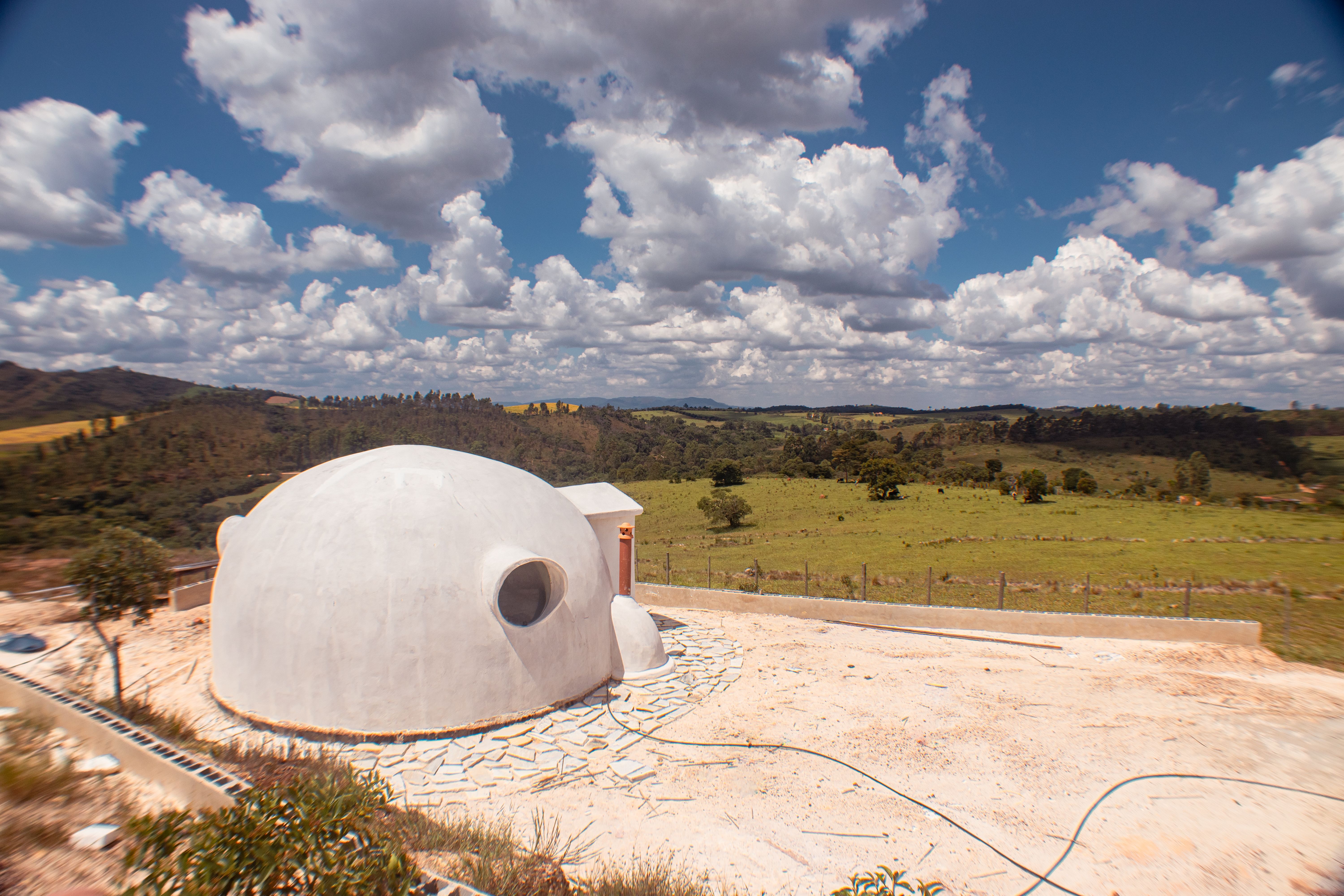 A white concrete dome home on a hilltop in open countryside, the geodesic dome homes guide