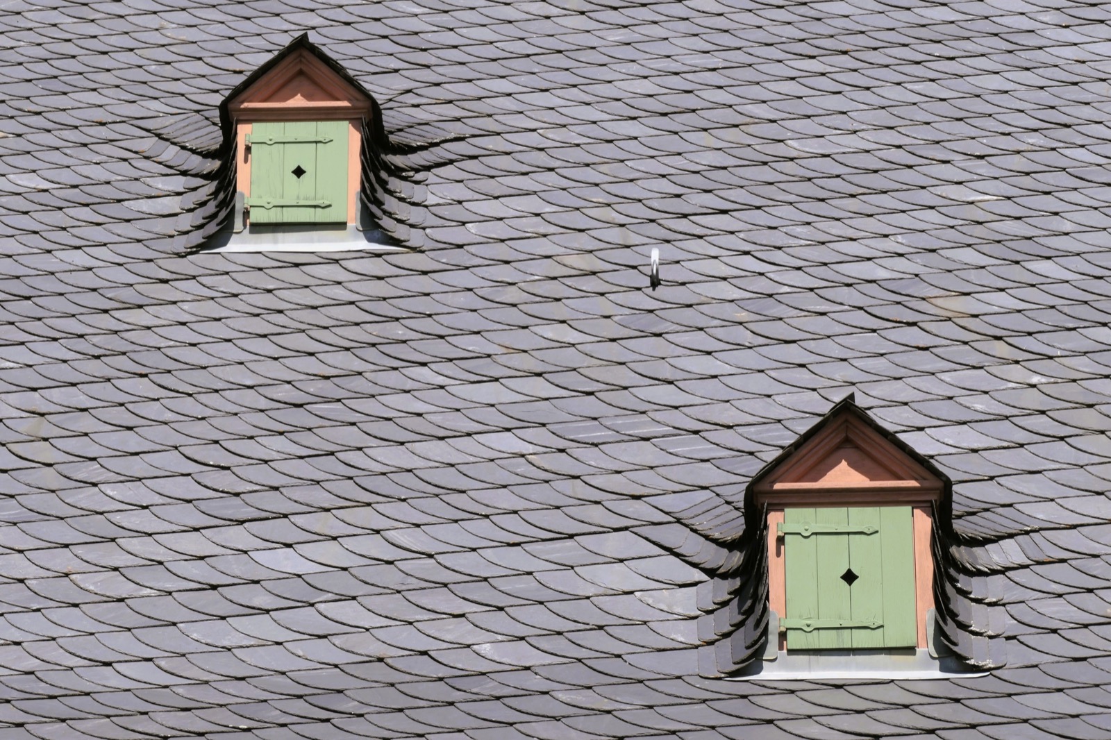 A grey asphalt shingle roof with dormers