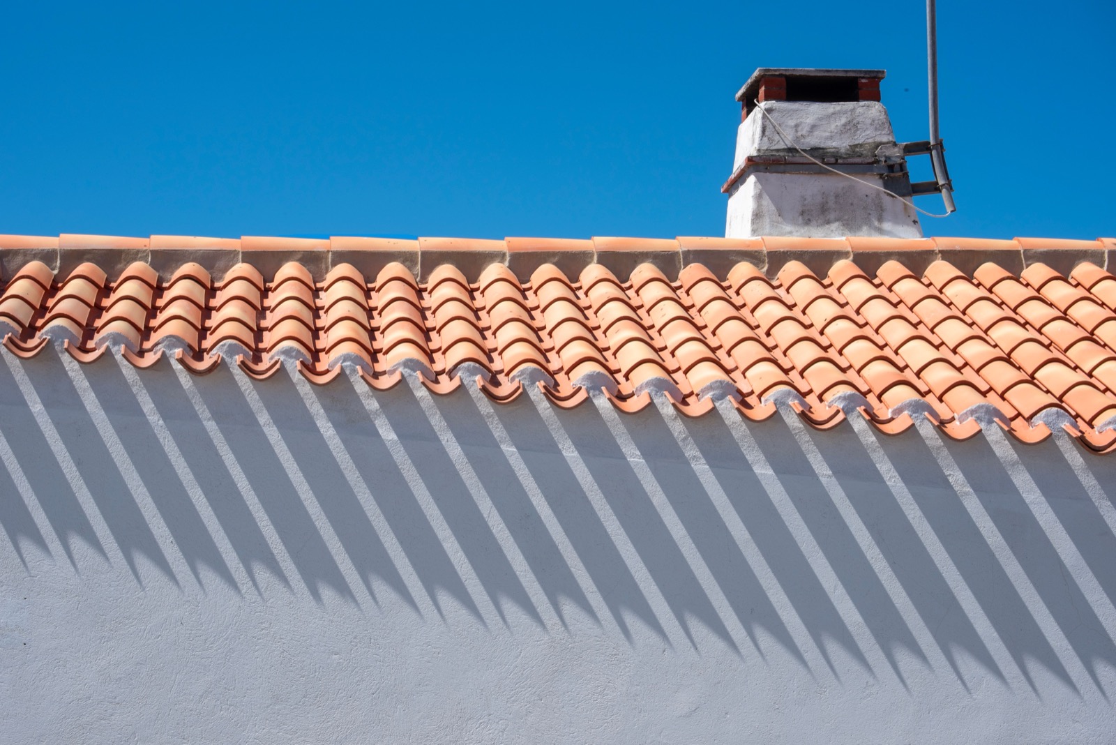A terracotta tile roof against a blue tropical sky — roofing materials guide